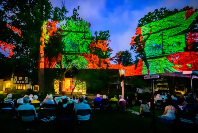 Projection on the Erlanger House with people watching outside