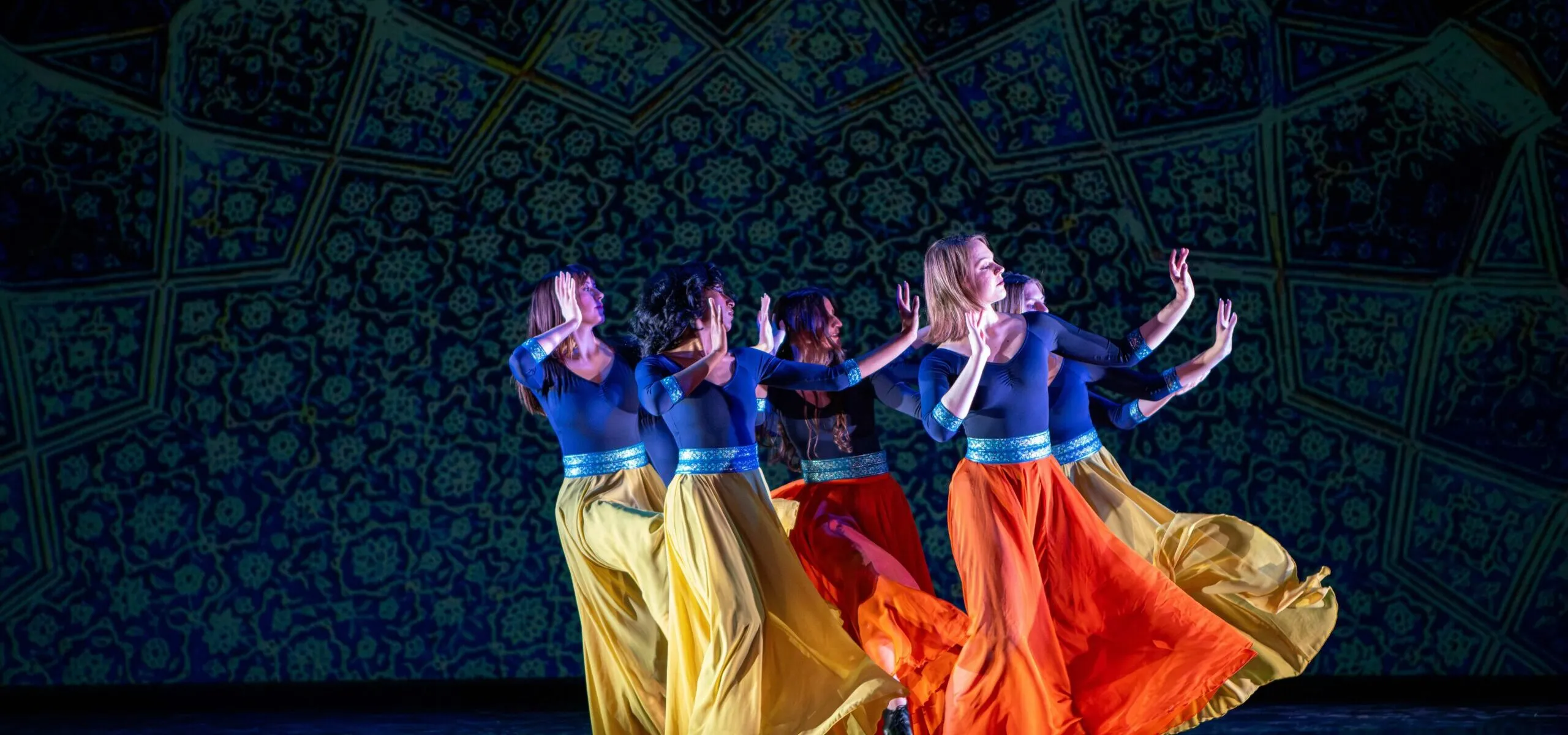 Dancers on stage with one dancer in a jump with a jumprope