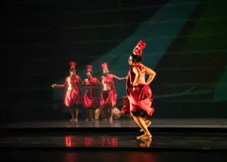 4 dancers on stage dressed in red 