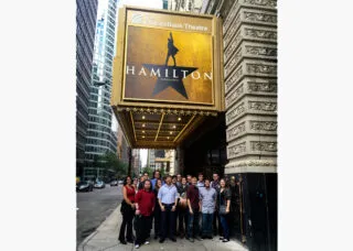 Lighting students in front of Hamilton marquee