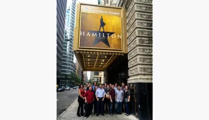 Lighting students in front of Hamilton marquee