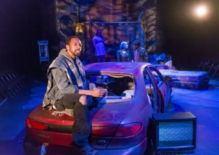 Young person sitting on trunk of car in Studio Theatre production