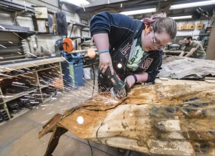 Student using power tool to cut object