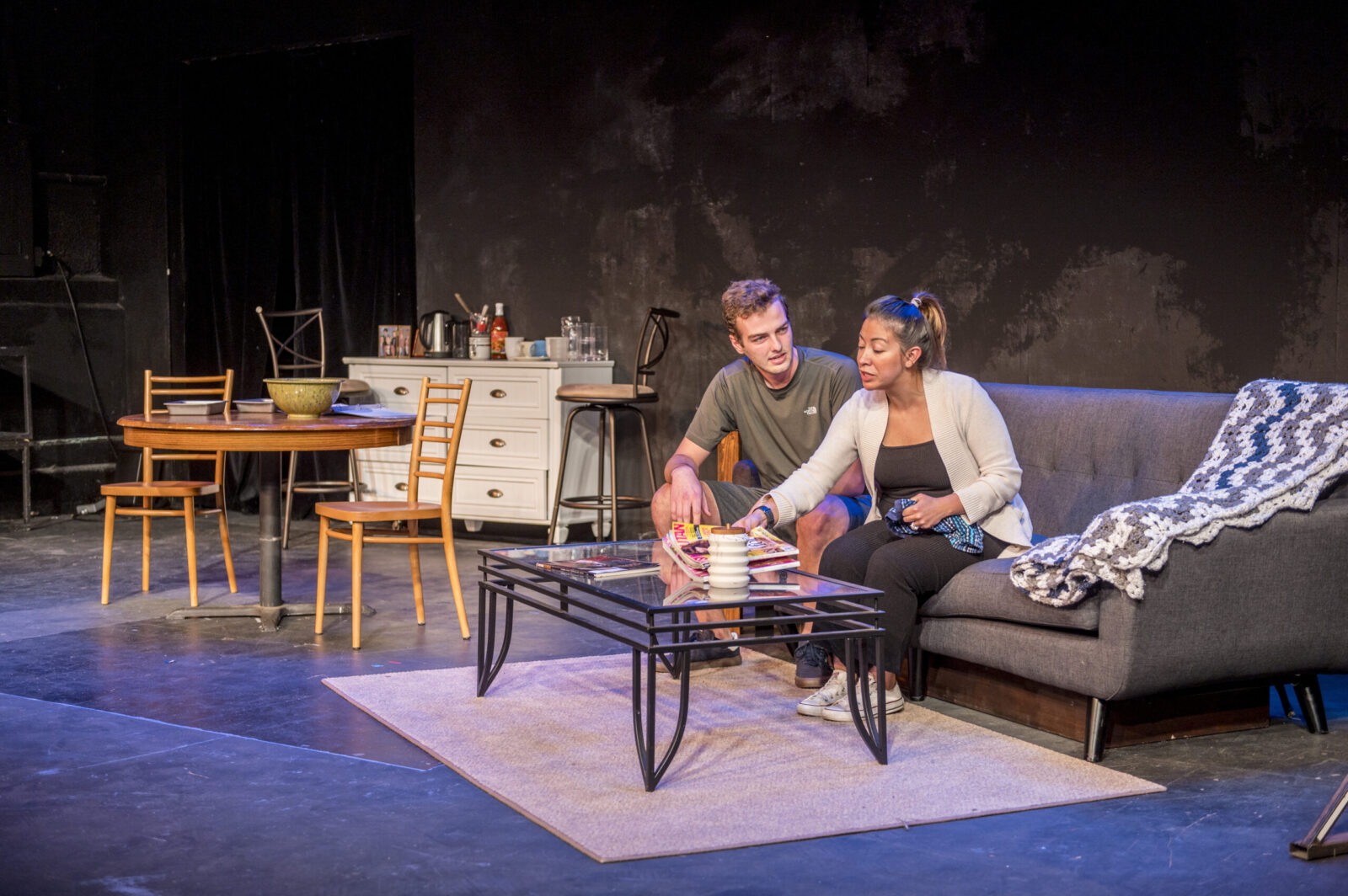 Two actors seated on sofa