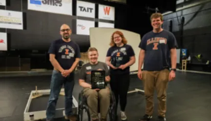 fours students wearing Illinois shirts and holding a plaque prize