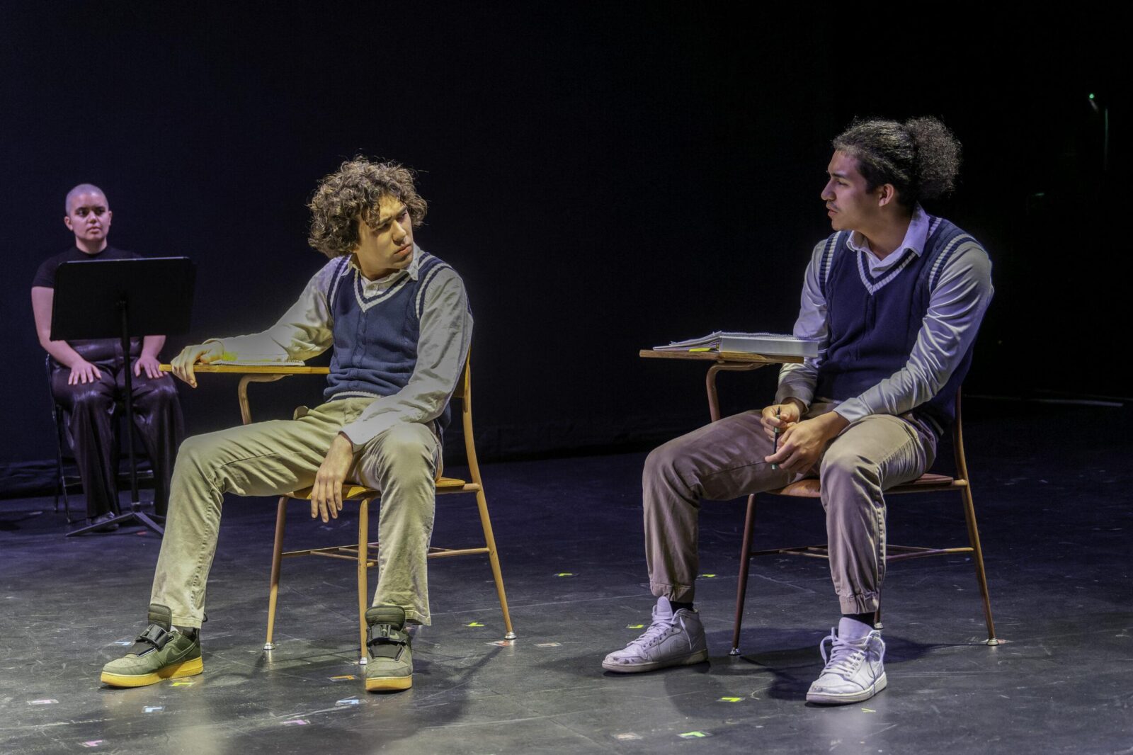 3 actors on stage sitting on benches 