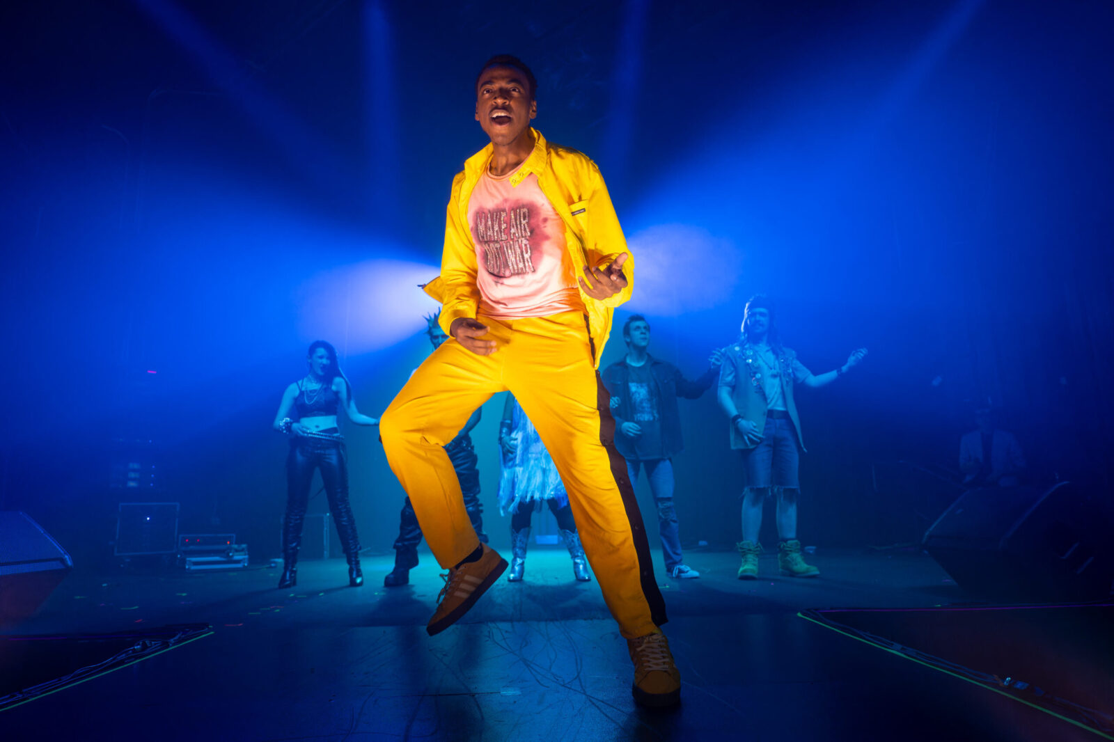 person playing air guitar in yellow suit