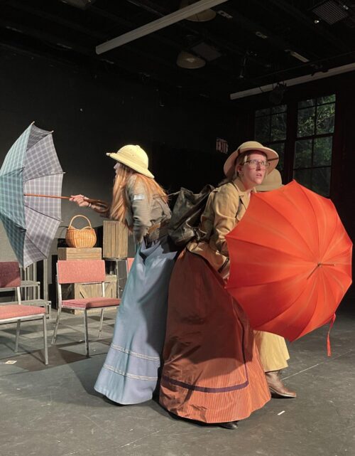 two actors wearing large dresses with umbrellas