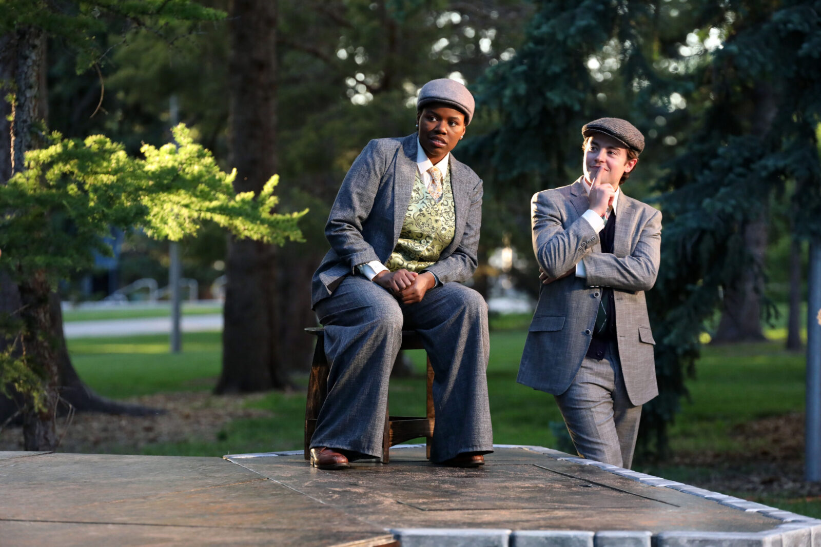2 people outdoors in costume suits looking out