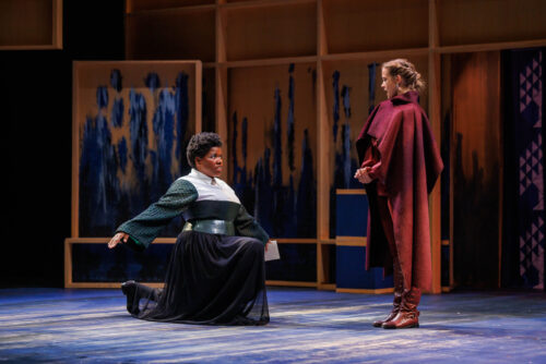 2 people onstage, one kneels before the other