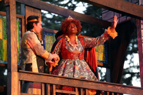 2 people onstage, one with arm stretched out