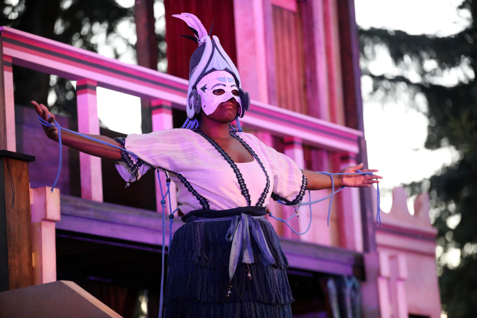 person onstage outdoors with arms outstretched