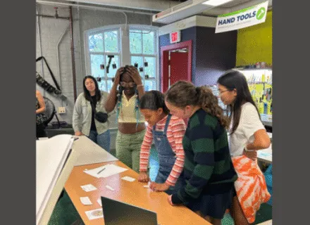 several students together looking at table with game items
