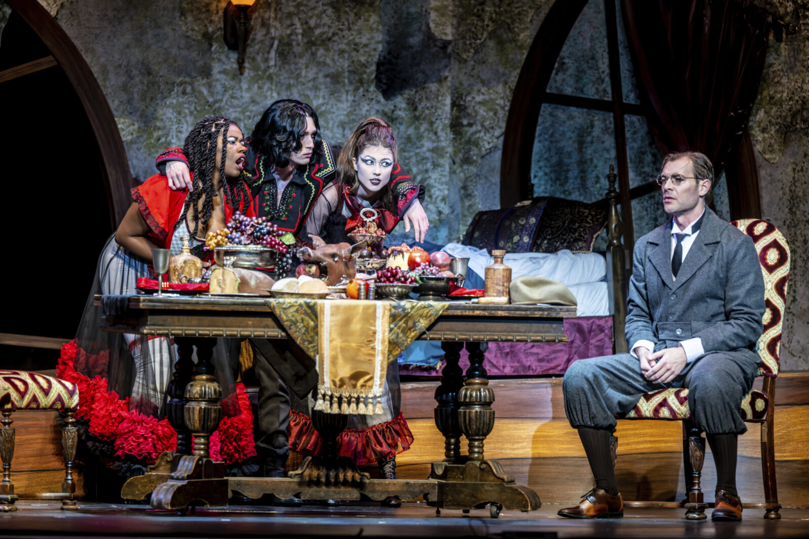 four people onstage around a dinner table