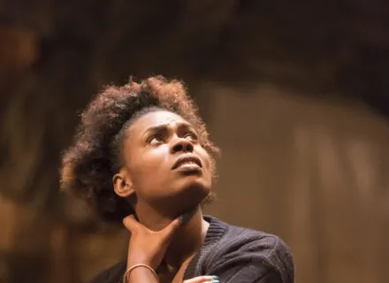 Actress from Illinois Theatre production looking up with arms crossed