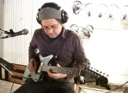 Nick Rudd in the studio playing guitar