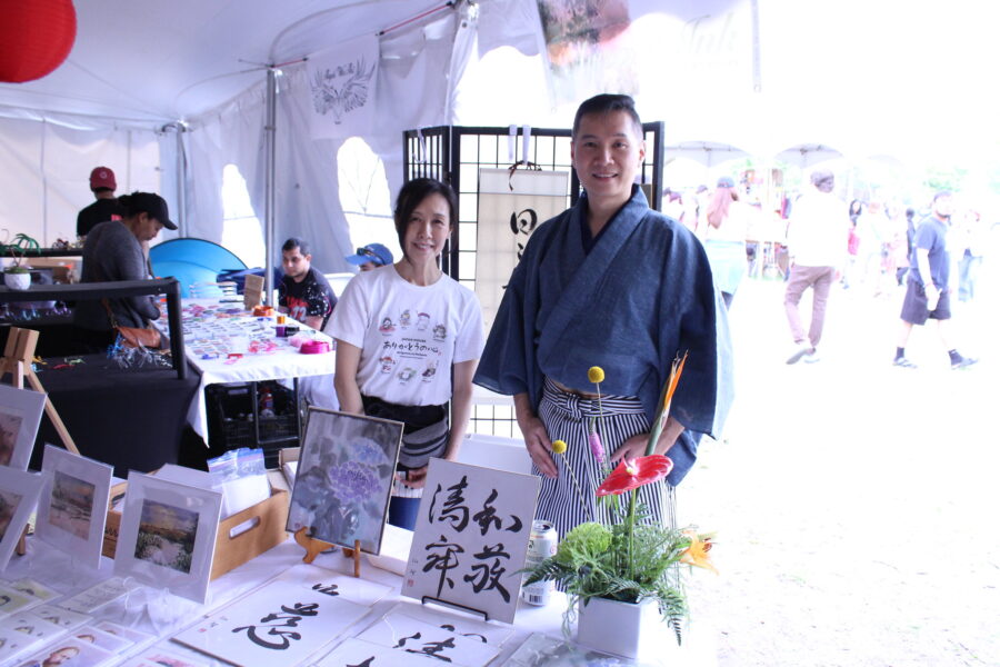 woman and man standing in front of Japanese art