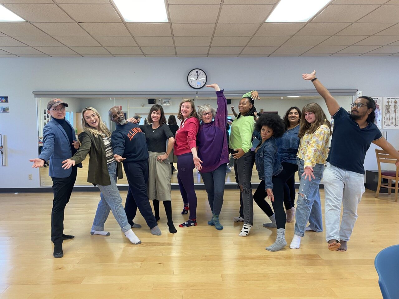 students and professors stand and pose in a dance studio