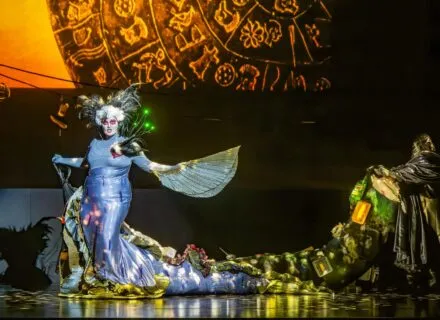 actor onstage in lit-up costume