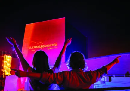 two people with arms raised outside the krannert center