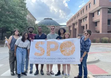 Students holding up sign that says SPO