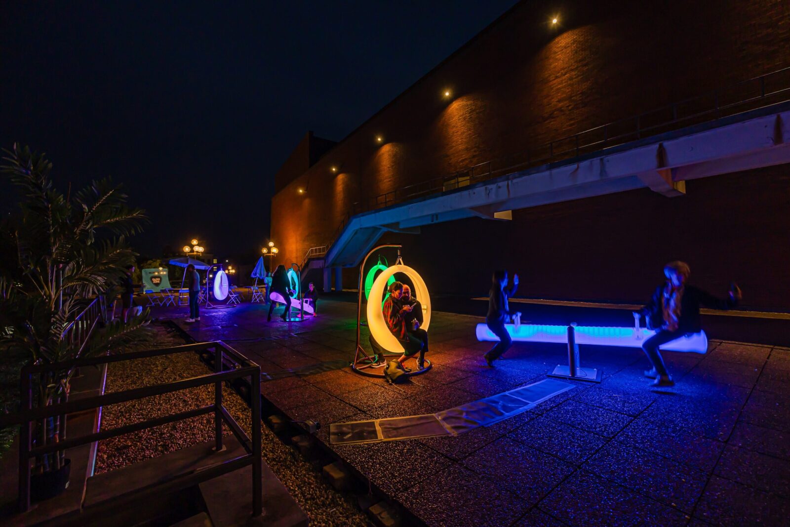people sitting in glow in the dark playground equipment