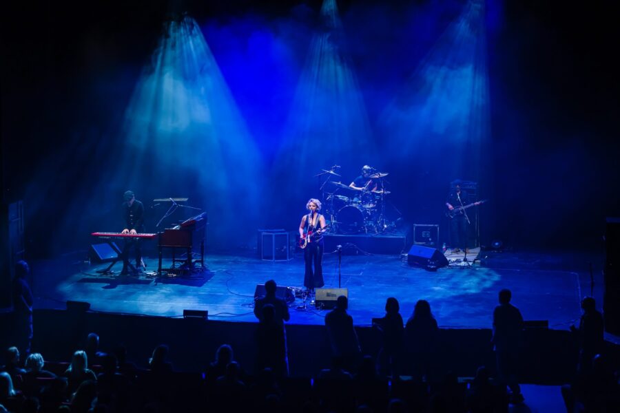 Woman playing guitar on stage
