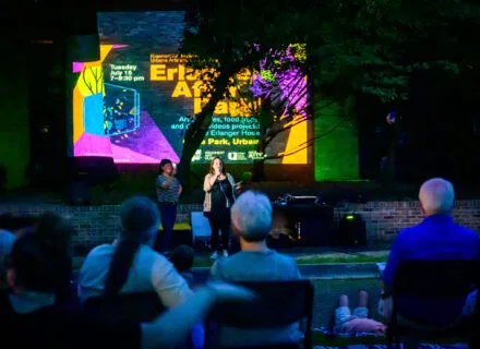 people gathered outside with projections on building facade