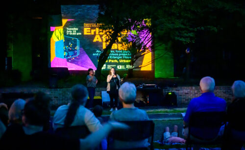 people gathered outside with projections on building facade