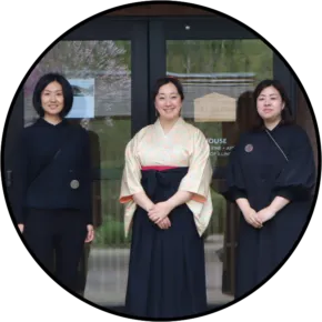 three people standing together in front of glass doors