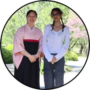 two people standing next to each other outdoors 