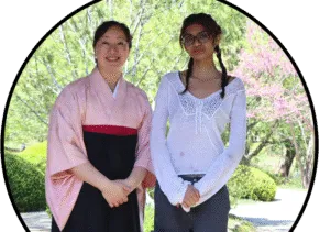 two people standing next to each other outdoors 