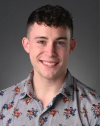 Man smiling in floral shirt, brown hair