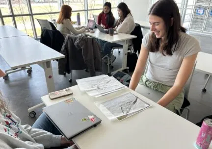 girl sitting in front of capstone work at a desk